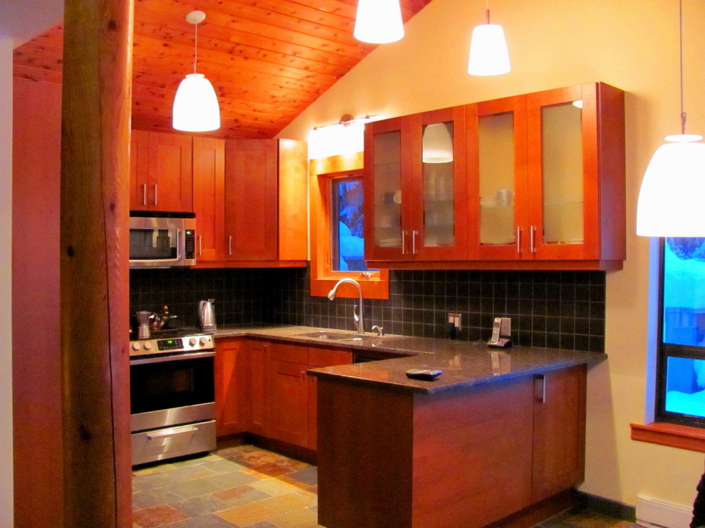 Mid-sized mountain style u-shaped slate floor kitchen photo with an undermount sink, shaker cabinets, granite countertops, black backsplash, ceramic backsplash, stainless steel appliances and a peninsula