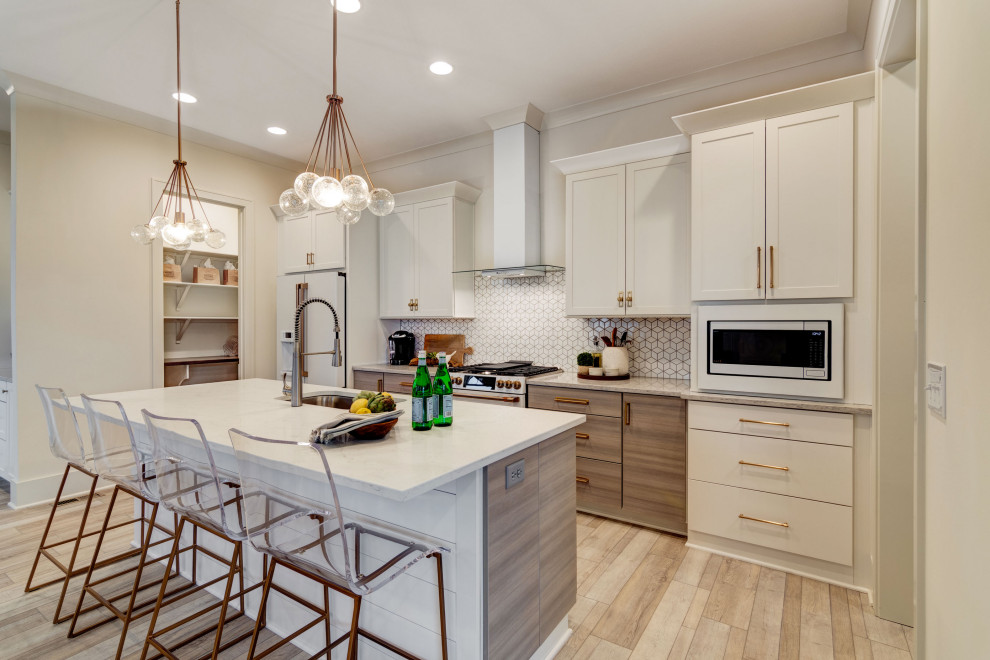 Mid-sized transitional single-wall kitchen in Indianapolis with an undermount sink, shaker cabinets, white cabinets, granite benchtops, white splashback, ceramic splashback, white appliances, vinyl floors, with island, multi-coloured floor and white benchtop.