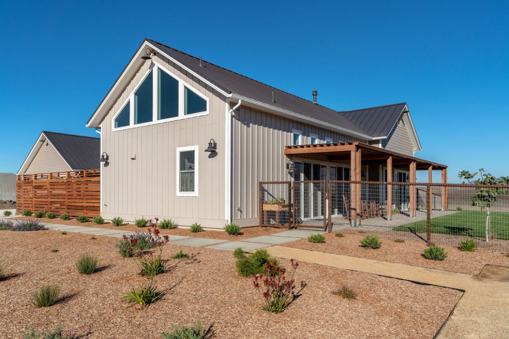 Inspiration for a large and beige farmhouse bungalow detached house in San Luis Obispo with wood cladding, a pitched roof, a metal roof, a brown roof and board and batten cladding.