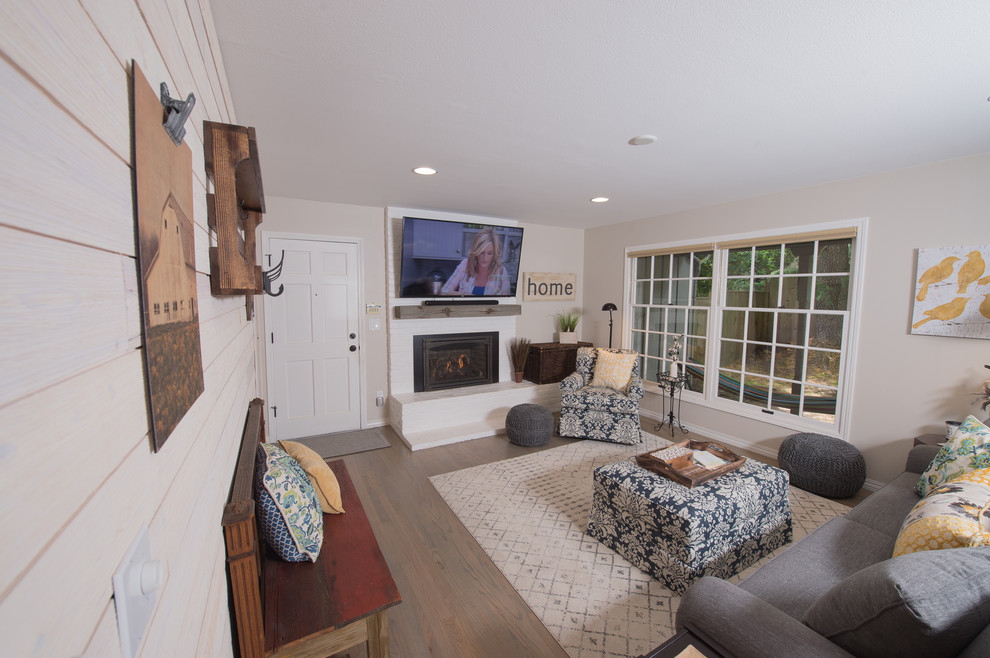 Design ideas for a mid-sized beach style enclosed family room in Portland with beige walls, light hardwood floors, a standard fireplace, a brick fireplace surround, a wall-mounted tv and beige floor.