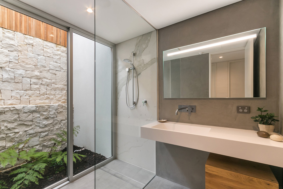 This is an example of an industrial master bathroom in Perth with white tile, marble, grey walls, an integrated sink, engineered quartz benchtops, grey floor, an open shower, white benchtops, a single vanity, a floating vanity and a curbless shower.