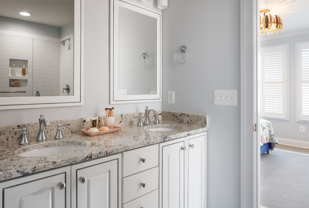 Photo of a mid-sized transitional master bathroom in Other with recessed-panel cabinets, white cabinets, an alcove shower, white tile, subway tile, blue walls, an undermount sink, granite benchtops and a hinged shower door.