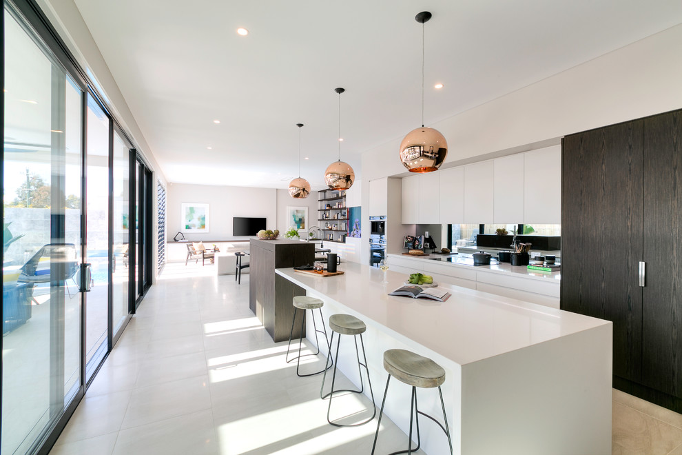 Contemporary galley open plan kitchen in Sydney with flat-panel cabinets, white cabinets, stainless steel appliances and with island.