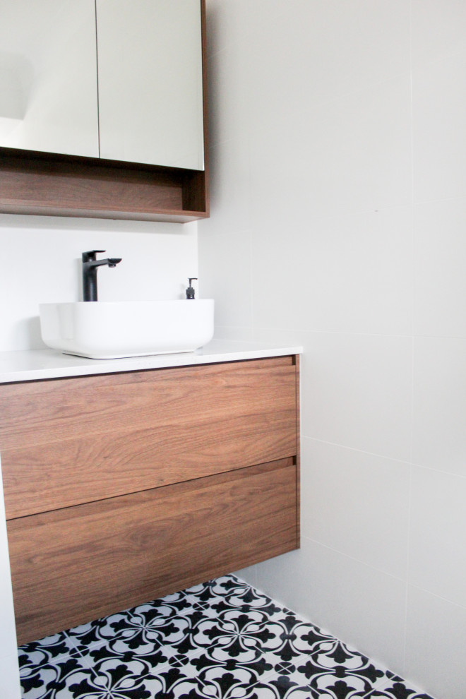 Photo of a mid-sized modern kids bathroom in Perth with flat-panel cabinets, dark wood cabinets, an open shower, white tile, ceramic tile, white walls, mosaic tile floors, a vessel sink, black floor, an open shower, white benchtops, a niche, a single vanity and a floating vanity.