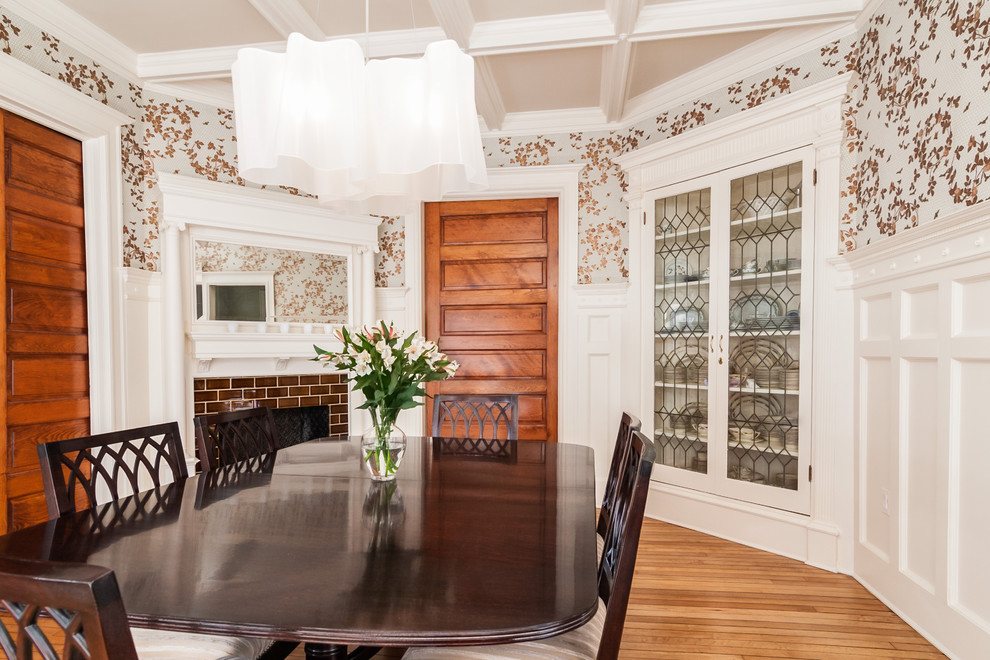 This is an example of a traditional dining room in DC Metro with medium hardwood floors and a tile fireplace surround.