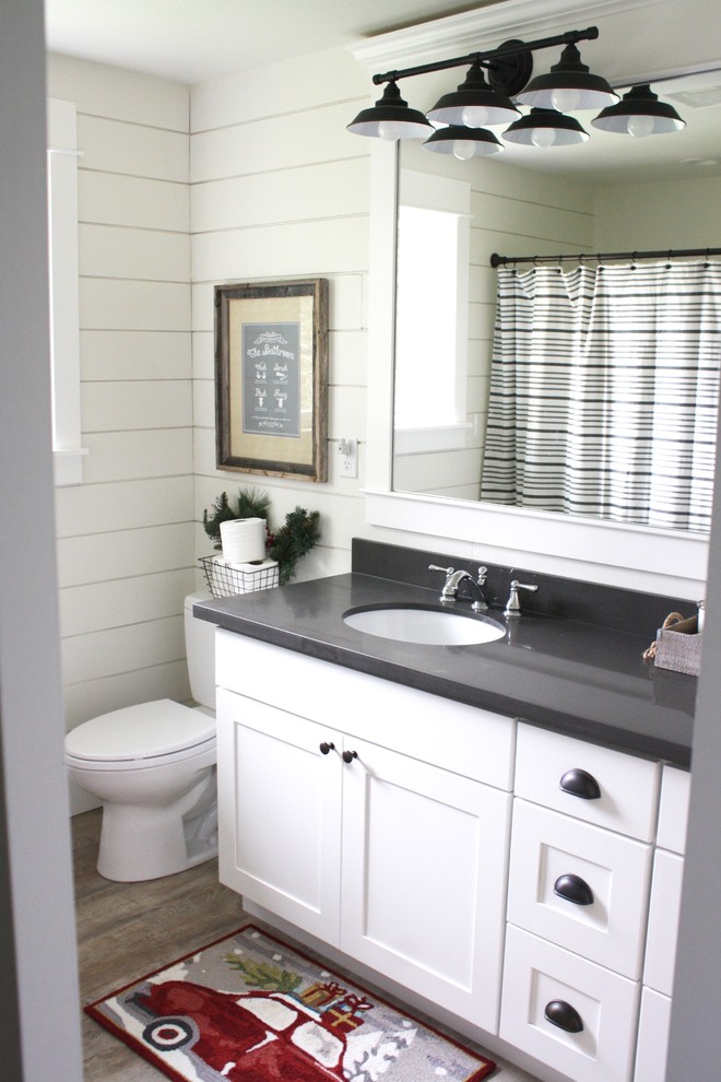 Mid-sized country kids bathroom in Seattle with shaker cabinets, white cabinets, a drop-in tub, a shower/bathtub combo, a one-piece toilet, white walls, vinyl floors, an undermount sink and engineered quartz benchtops.