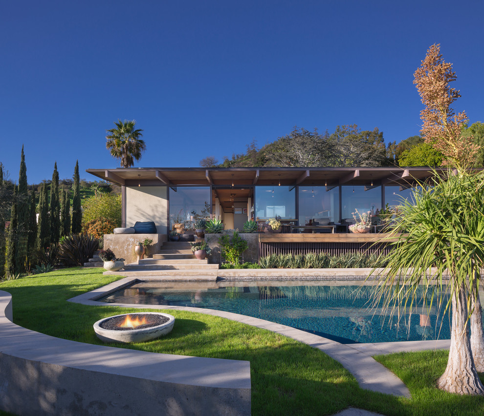 Design ideas for a midcentury one-storey glass house exterior in Los Angeles with a flat roof.