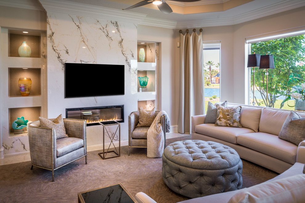 Transitional family room in Houston with beige walls, marble floors, a standard fireplace and a wall-mounted tv.