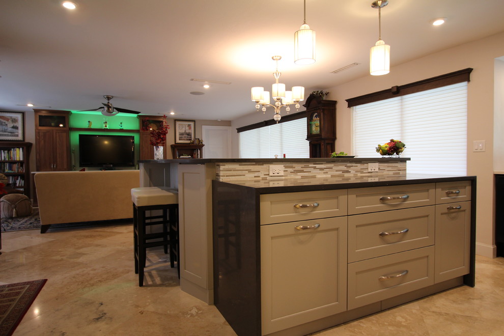 Transitional l-shaped eat-in kitchen photo in Miami with an undermount sink, flat-panel cabinets, gray cabinets, quartzite countertops, white backsplash, subway tile backsplash, black appliances and an island