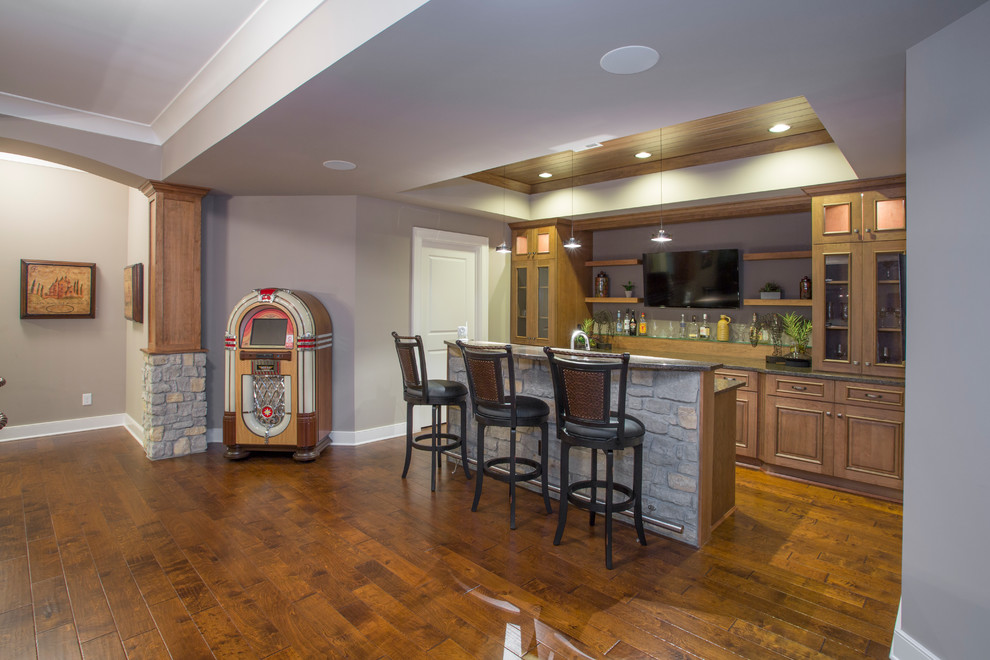 This is an example of a mid-sized transitional home bar in Cincinnati with medium hardwood floors.