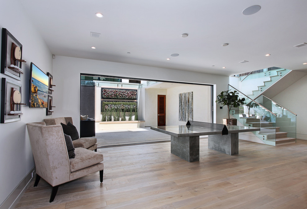 Contemporary family room in Orange County with white walls and light hardwood floors.