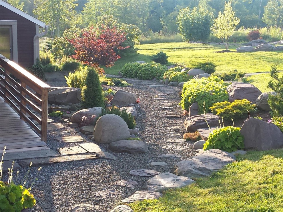This is an example of a mid-sized traditional side yard partial sun garden in New York with natural stone pavers.
