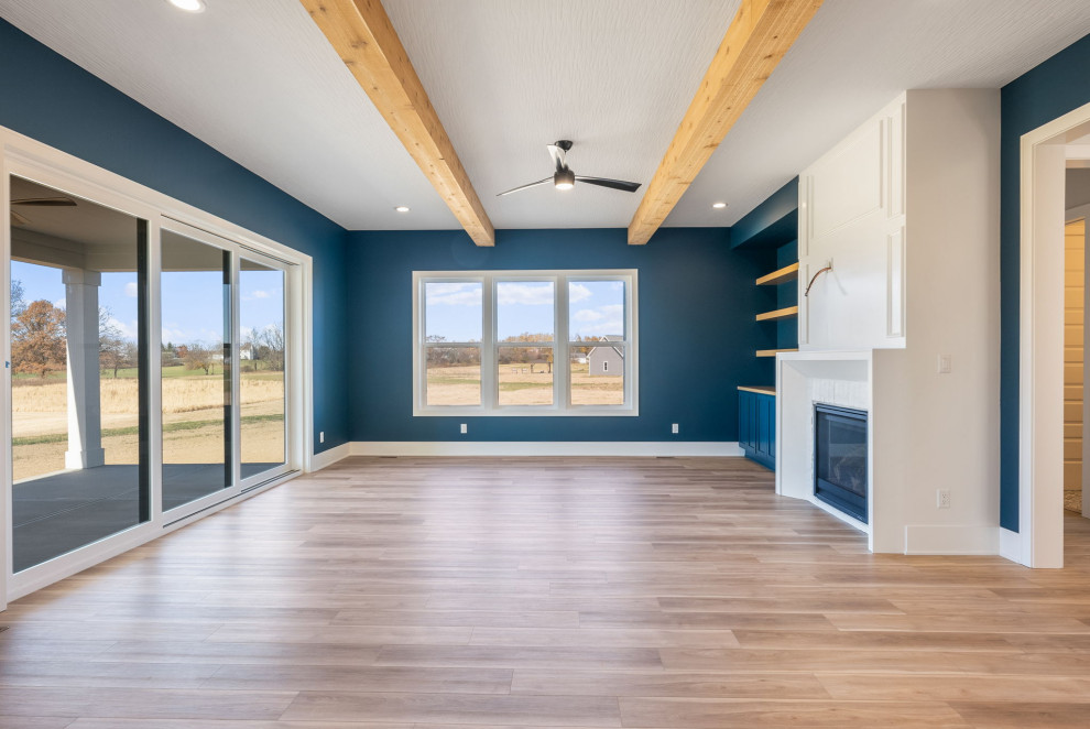 Стильный дизайн: открытая гостиная комната в стиле неоклассика (современная классика) с синими стенами, стандартным камином, фасадом камина из дерева, телевизором на стене и балками на потолке - последний тренд