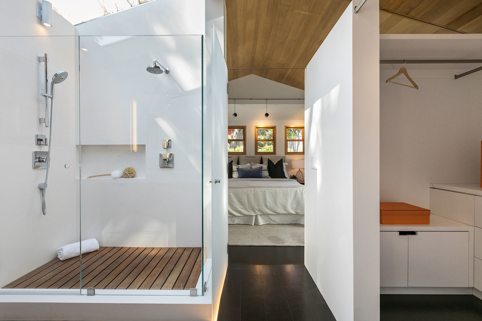 This is an example of an eclectic master bathroom in San Francisco with flat-panel cabinets, medium wood cabinets, a corner shower, a one-piece toilet, white tile, stone slab, white walls, slate floors, a vessel sink, engineered quartz benchtops, multi-coloured floor, a hinged shower door and white benchtops.
