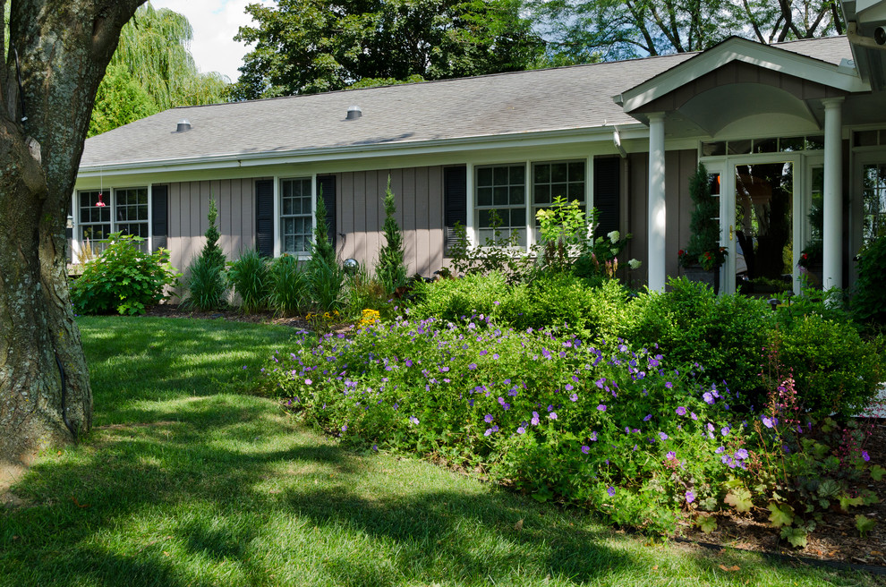 This is an example of a mid-sized transitional front yard shaded garden for summer in Milwaukee with mulch.