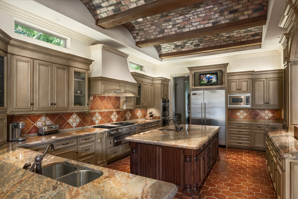 Large traditional u-shaped separate kitchen in Dallas with a double-bowl sink, beige cabinets, brown splashback, stainless steel appliances, recessed-panel cabinets, granite benchtops, terra-cotta splashback, terra-cotta floors and with island.