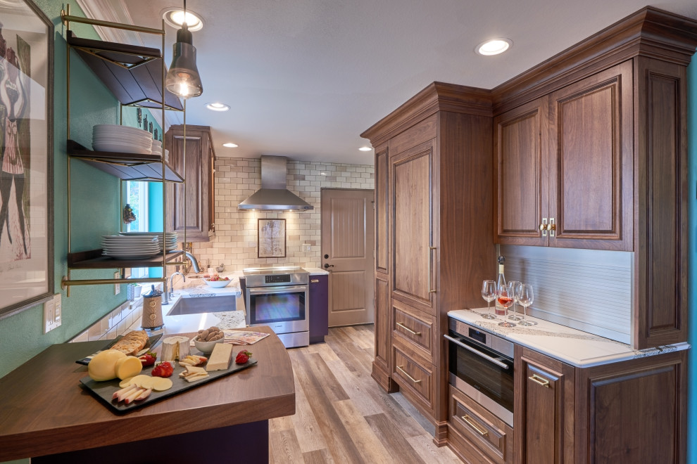 This is an example of an eclectic galley eat-in kitchen in Portland with a farmhouse sink, raised-panel cabinets, purple cabinets, quartz benchtops, brown splashback, ceramic splashback, panelled appliances, laminate floors, no island, grey floor and white benchtop.