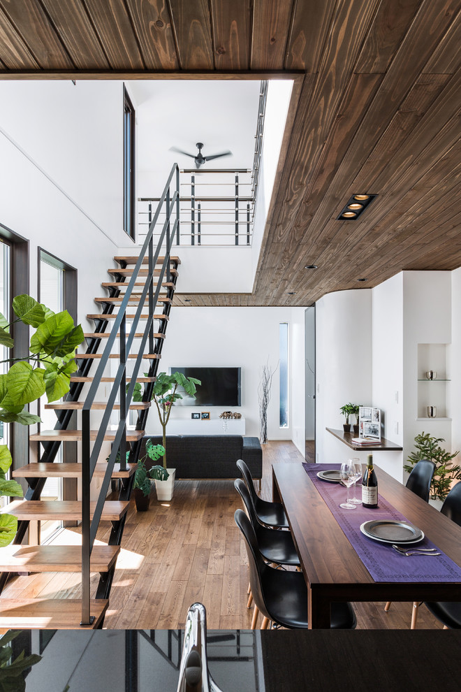 他の地域にあるミッドセンチュリースタイルのおしゃれなLDK (白い壁、無垢フローリング、茶色い床) の写真