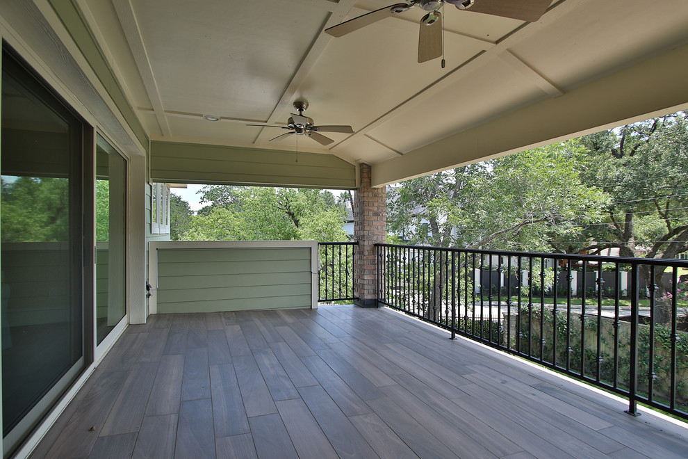 Inspiration for a large country balcony in Houston with a roof extension and metal railing.