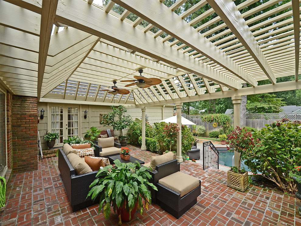 Design ideas for a large traditional backyard patio in Other with a pergola, a water feature and brick pavers.