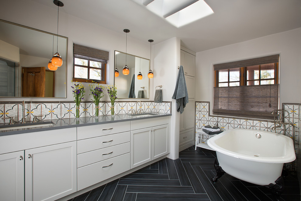 This is an example of a master bathroom in Albuquerque with an undermount sink, shaker cabinets, white cabinets, a claw-foot tub, multi-coloured tile, white walls and black floor.