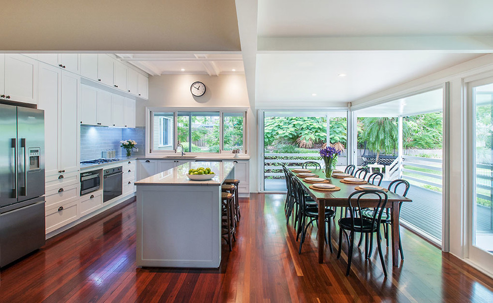 This is an example of a mid-sized contemporary galley eat-in kitchen in Brisbane with an undermount sink, shaker cabinets, white cabinets, granite benchtops, grey splashback, ceramic splashback, stainless steel appliances, dark hardwood floors and with island.