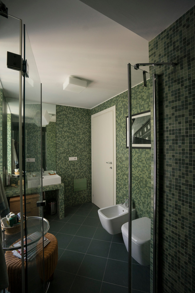 На фото: маленькая главная ванная комната в современном стиле с столешницей из плитки, душем в нише, раздельным унитазом, зеленой плиткой, плиткой мозаикой, зелеными стенами, полом из керамической плитки, плоскими фасадами, светлыми деревянными фасадами, раковиной с несколькими смесителями, зеленым полом, душем с распашными дверями и зеленой столешницей для на участке и в саду