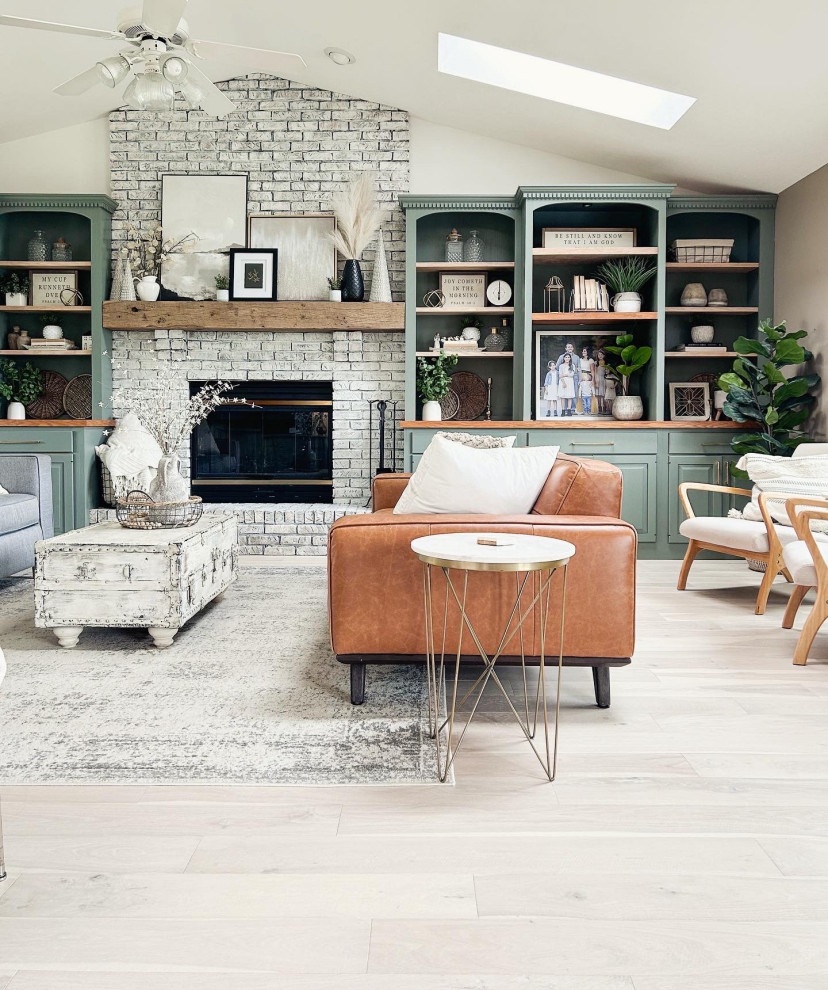 Mid-sized country open concept living room in Los Angeles with multi-coloured walls, light hardwood floors, a standard fireplace, a brick fireplace surround, a built-in media wall, white floor and vaulted.