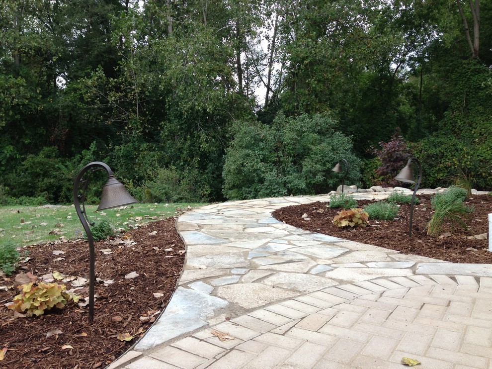 This is an example of a large country backyard full sun formal garden in Detroit with a garden path and natural stone pavers.