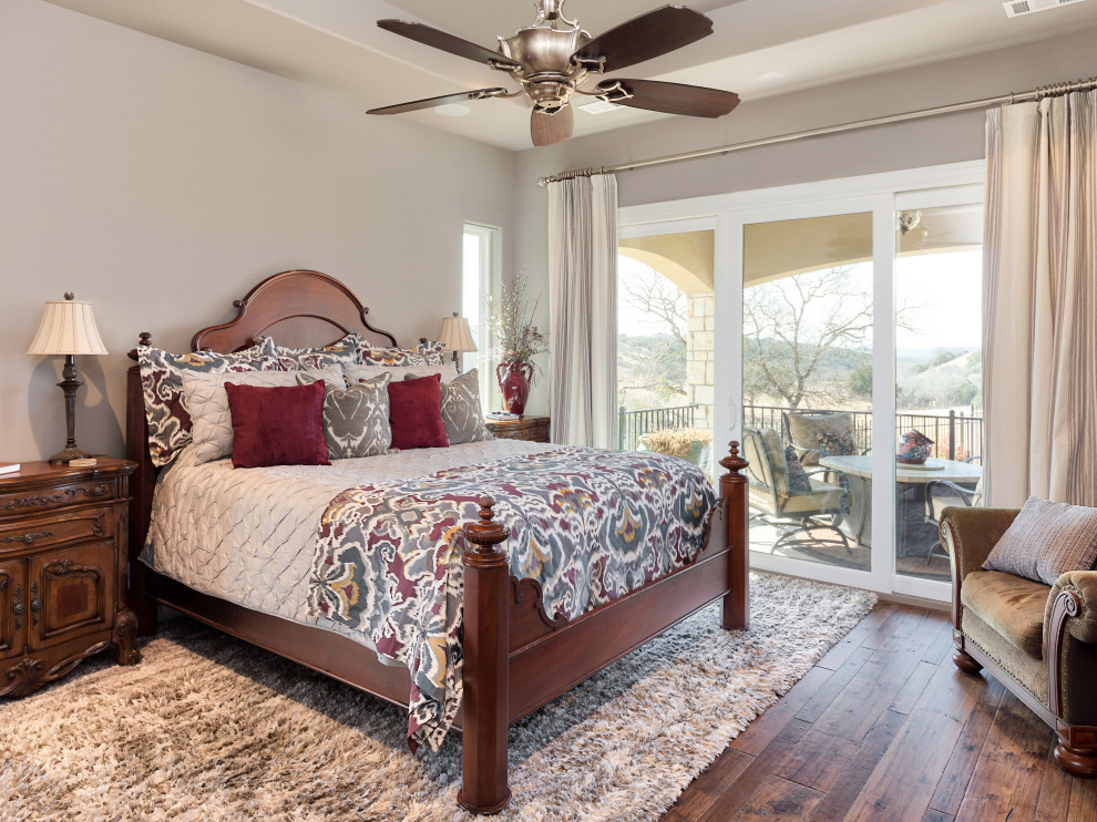 Design ideas for a traditional master bedroom in Austin with beige walls, medium hardwood floors and brown floor.