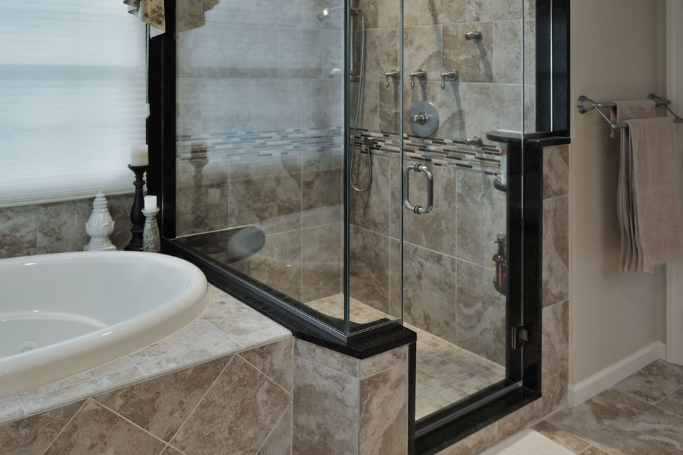 This is an example of a large traditional master bathroom in Philadelphia with an undermount sink, raised-panel cabinets, dark wood cabinets, granite benchtops, a drop-in tub, a corner shower, a two-piece toilet, beige tile, porcelain tile, beige walls and porcelain floors.