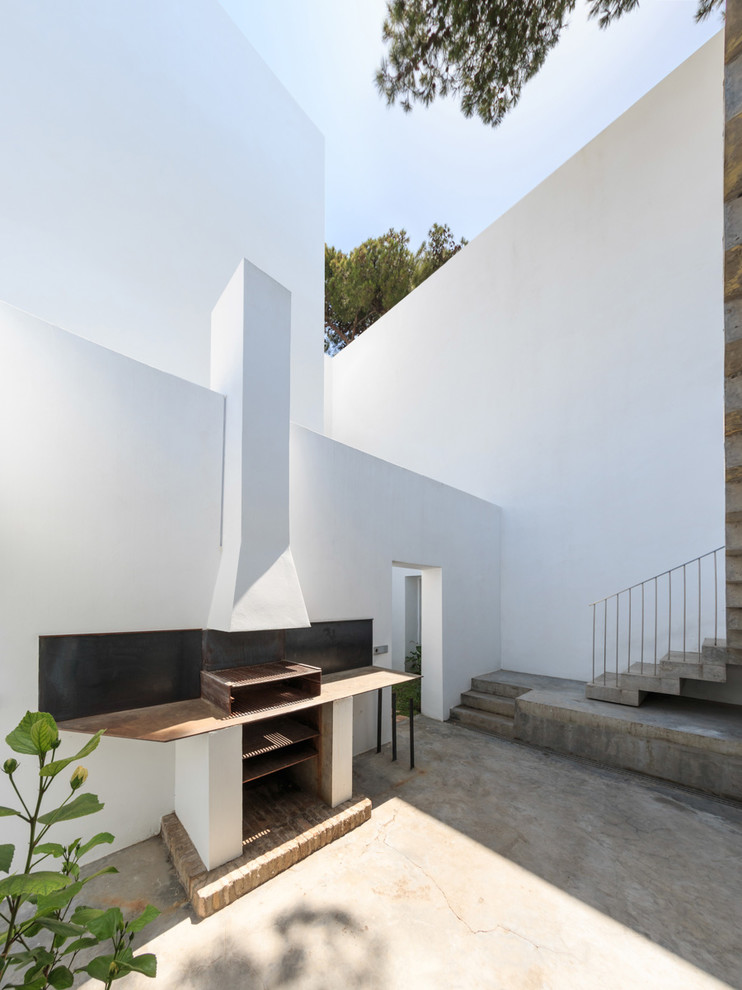 Ejemplo de patio actual de tamaño medio sin cubierta en patio con losas de hormigón y brasero