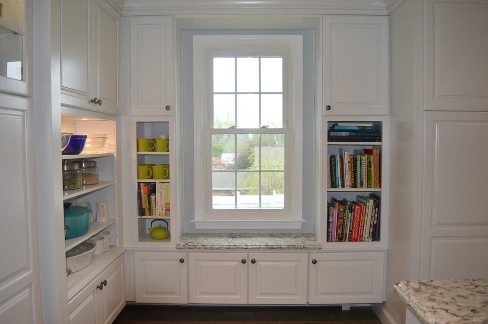 Example of a large transitional u-shaped ceramic tile and gray floor home design design with a farmhouse sink, raised-panel cabinets, white cabinets, quartz countertops, gray backsplash, glass tile backsplash, stainless steel appliances and an island