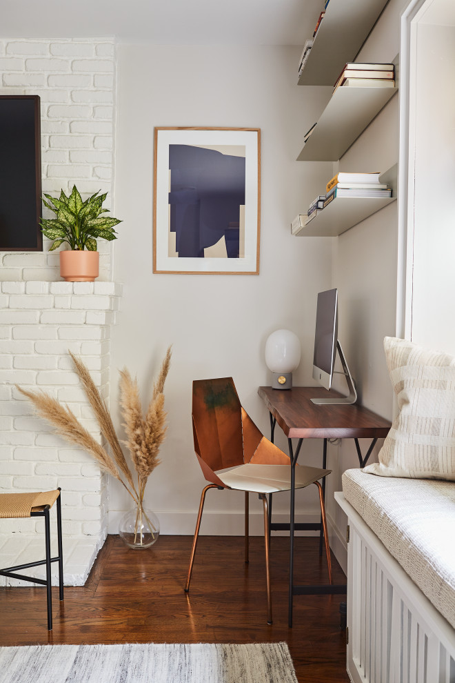Design ideas for a small classic home office in New York with white walls, medium hardwood flooring, a standard fireplace, a brick fireplace surround and a freestanding desk.