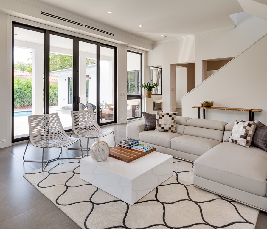 Mid-sized contemporary enclosed family room in Miami with white walls, concrete floors, no fireplace, a wall-mounted tv and grey floor.