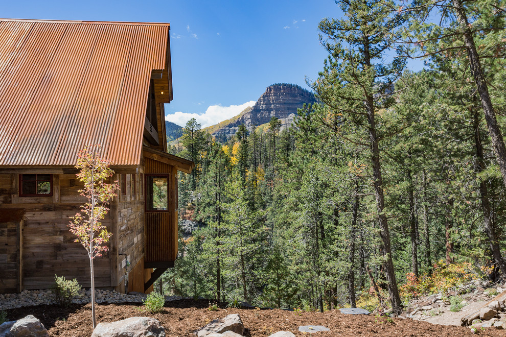 Large rustic multicolored two-story mixed siding house exterior idea with a shed roof and a metal roof