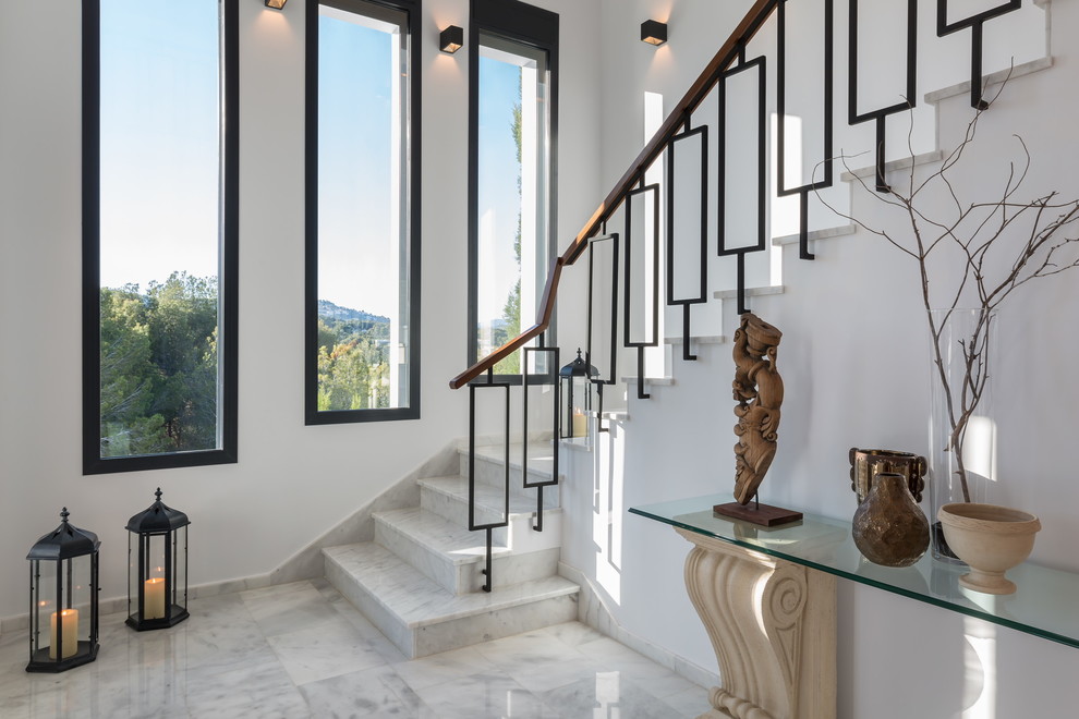Mid-sized transitional marble l-shaped staircase in Madrid with marble risers.