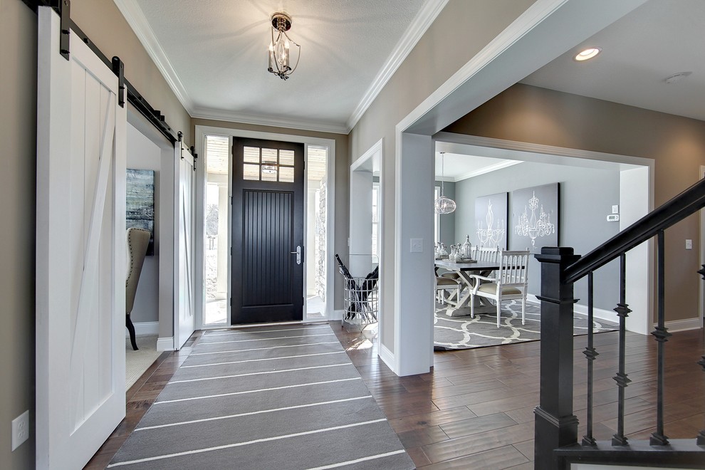 Design ideas for a large transitional foyer in Minneapolis with grey walls, dark hardwood floors, a single front door and a black front door.