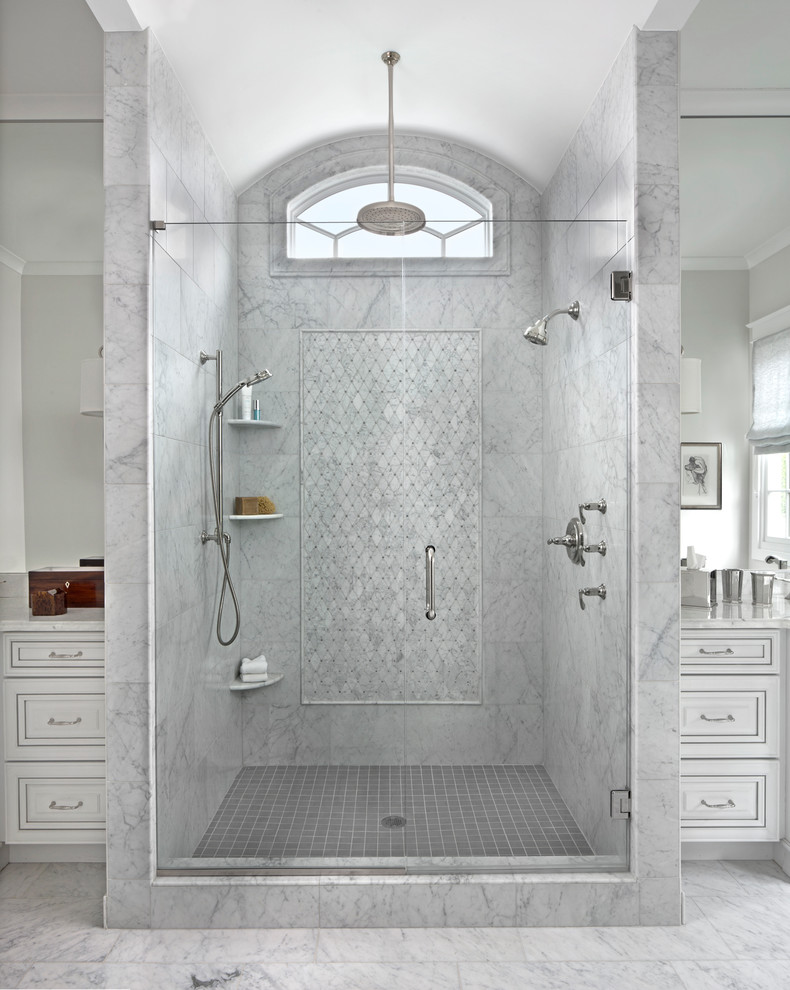 Photo of a large transitional master wet room bathroom in Detroit with a hinged shower door, raised-panel cabinets, white cabinets, marble floors and an undermount sink.