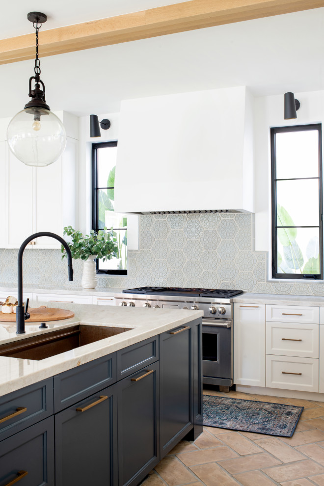 Inspiration for a large mediterranean l-shaped terra-cotta tile and beige floor open concept kitchen remodel in Los Angeles with a farmhouse sink, recessed-panel cabinets, blue cabinets, marble countertops, blue backsplash, ceramic backsplash, colored appliances, an island and beige countertops