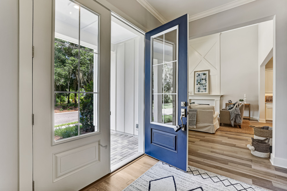 Idée de décoration pour une entrée minimaliste avec un mur gris, une porte double, une porte bleue et un sol marron.
