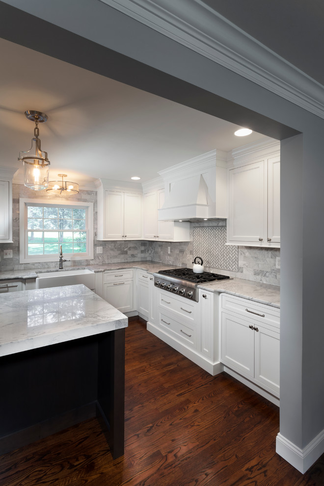 Large transitional eat-in kitchen in Detroit with a farmhouse sink, raised-panel cabinets, white cabinets, marble benchtops, grey splashback, dark hardwood floors and with island.