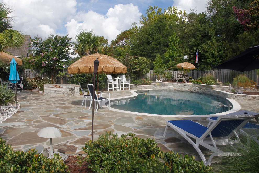 Design ideas for a traditional backyard custom-shaped pool in Other with with a pool and natural stone pavers.