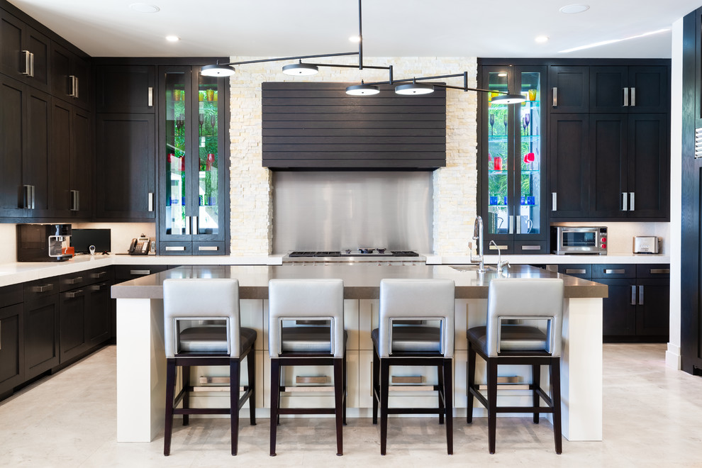 Inspiration for a transitional l-shaped kitchen in Tampa with an undermount sink, shaker cabinets, black cabinets, metallic splashback, stainless steel appliances, with island, beige floor and beige benchtop.