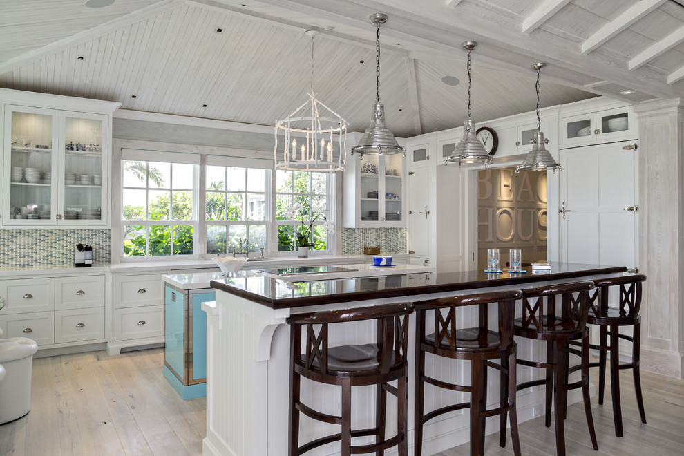 Photo of a beach style kitchen in Miami with glass-front cabinets.