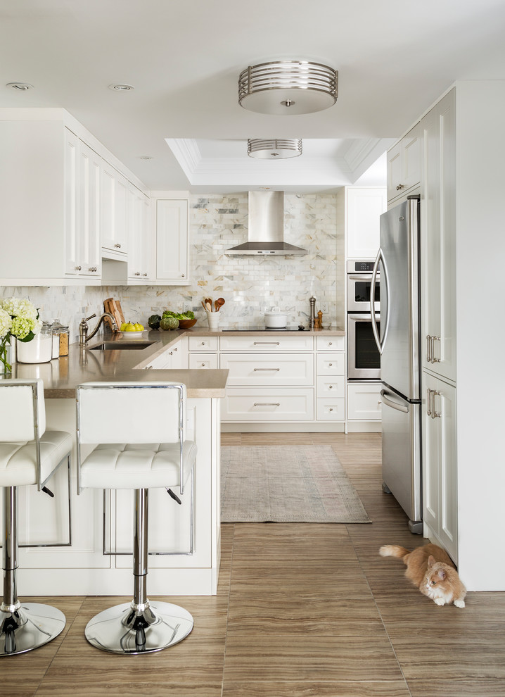 Inspiration for a traditional u-shaped kitchen in Toronto with an undermount sink, shaker cabinets, white cabinets, multi-coloured splashback, stainless steel appliances, a peninsula and beige floor.