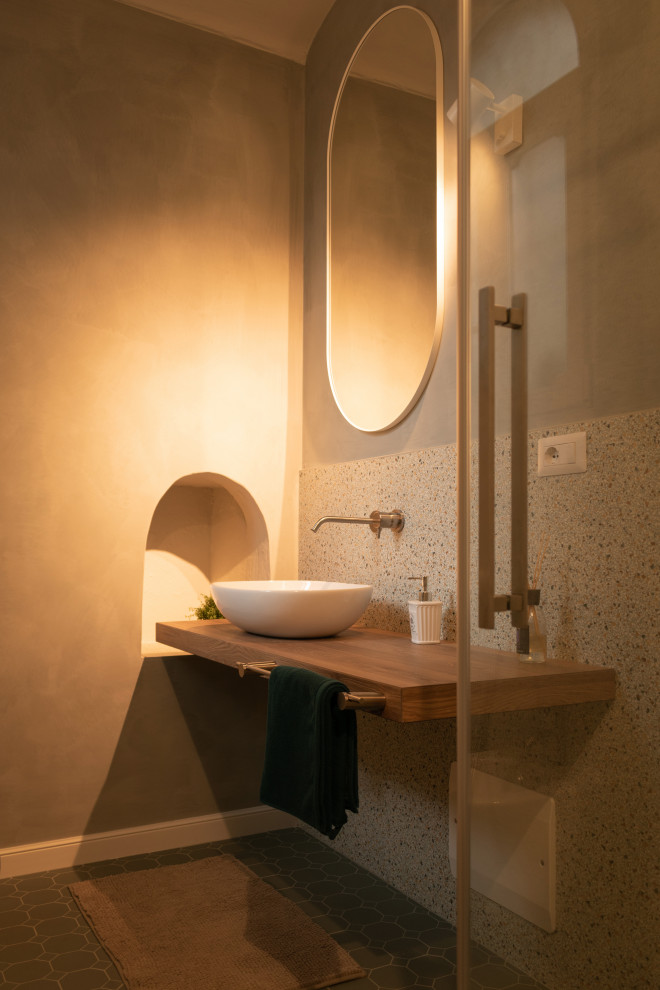 Exempel på ett litet modernt brun brunt badrum med dusch, med skåp i ljust trä, en kantlös dusch, en toalettstol med separat cisternkåpa, flerfärgad kakel, mosaik, grå väggar, klinkergolv i keramik, ett fristående handfat, träbänkskiva, grönt golv och dusch med skjutdörr