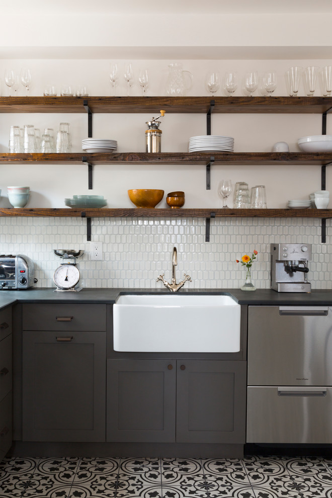 Inspiration for a mid-sized eclectic l-shaped eat-in kitchen in Philadelphia with a farmhouse sink, flat-panel cabinets, grey cabinets, white splashback, ceramic splashback, stainless steel appliances, porcelain floors, no island and multi-coloured floor.