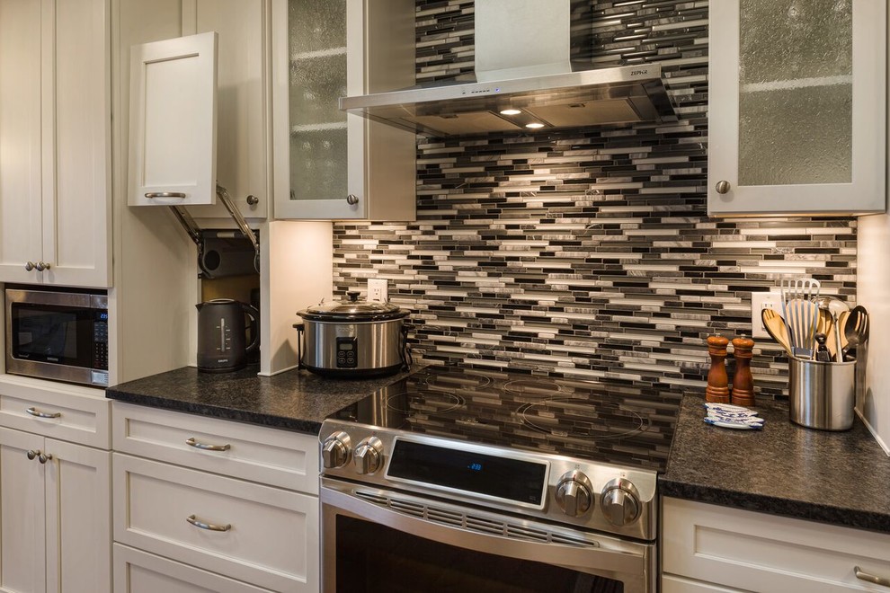 Mid-sized transitional galley medium tone wood floor eat-in kitchen photo in Seattle with an undermount sink, shaker cabinets, white cabinets, multicolored backsplash, matchstick tile backsplash, stainless steel appliances and no island