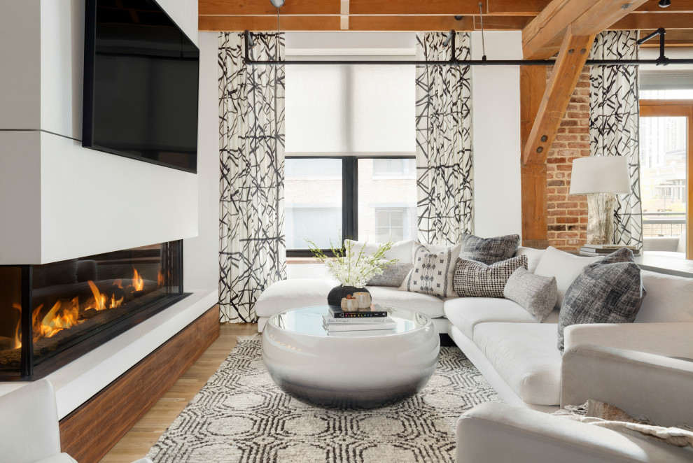 Photo of a small contemporary open plan living room in Denver with a two-sided fireplace, a stone fireplace surround, a wall mounted tv, white walls, medium hardwood flooring, brown floors and exposed beams.